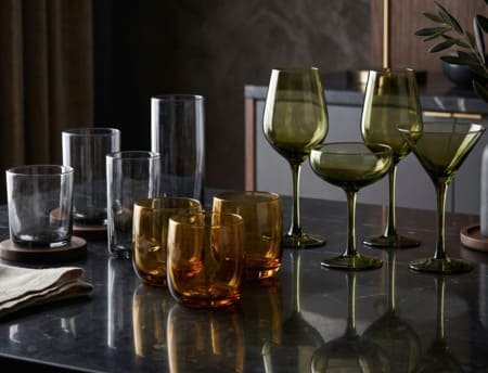 Premium through-colored glassware showcasing elegant smoke grey and amber tones
